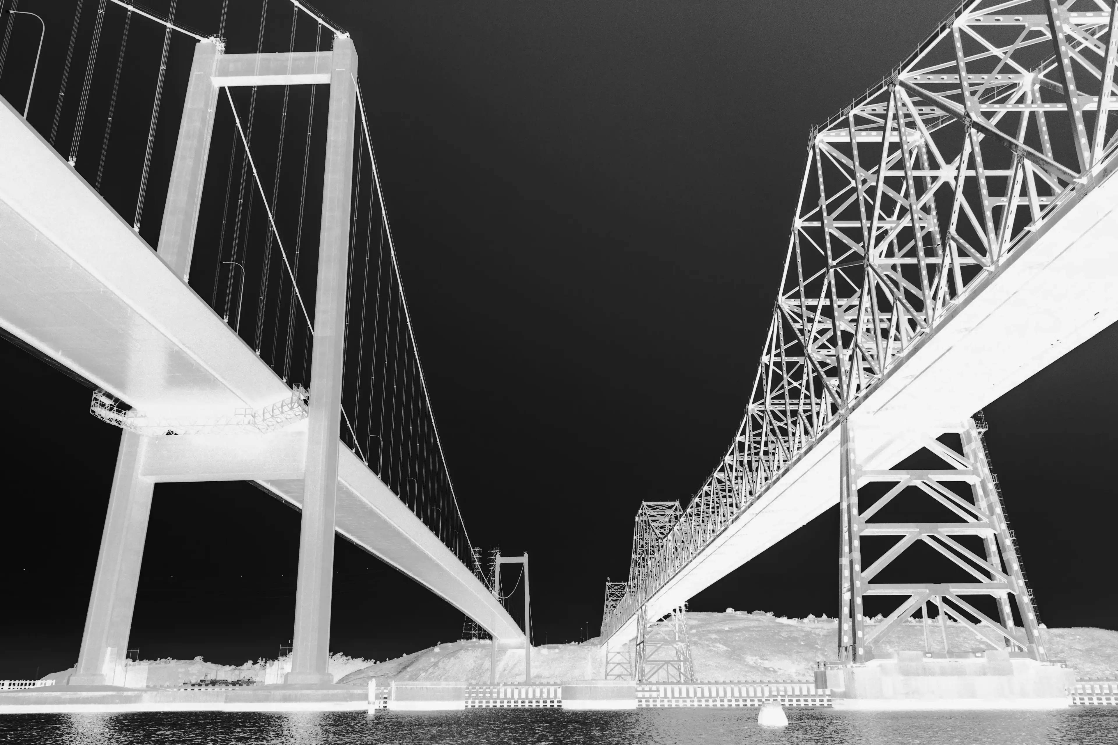 A black and white photo of the Carquinez Bridges from the water.