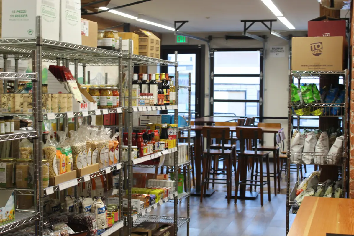 Olympia Market interior showing shelves of pantry staples and seating area